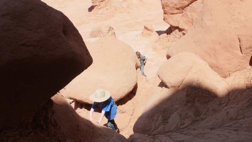 A family hiking through the rock formations in Goblin Valley State Park in Southern Utah