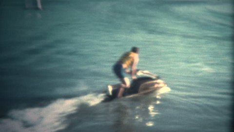 (Super 8 Vintage) Man Attempting to Ride JetSki Fail.  A retro super 8mm reel-to-reel home movie film professional clean and captured in full 4k (3840x2160 UHD) resolution plus footage restoration.