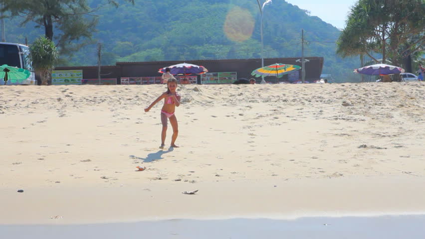 Little girl runs into the water.