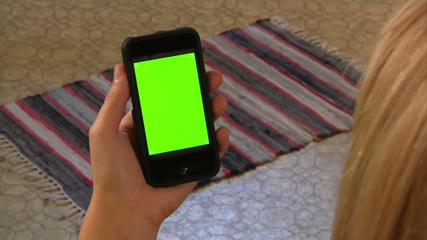 Female holding a mobile smartphone.  Green screen for your custom video content