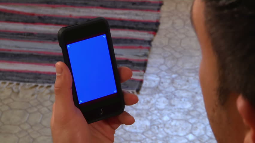 Male holding a mobile smartphone.  Blue screen for your custom video content