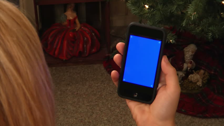 Female holding a mobile smartphone.  Blue screen for your custom video content