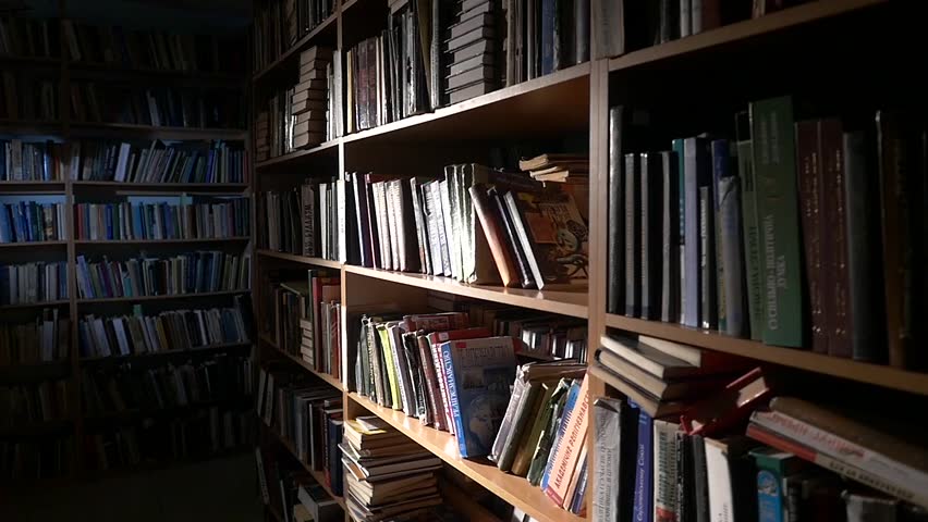 The guy puts the book in its place in the library. camera moves from left to right. Horizontal pan, leafing through the book, slow motion | Shutterstock HD Video #9927278