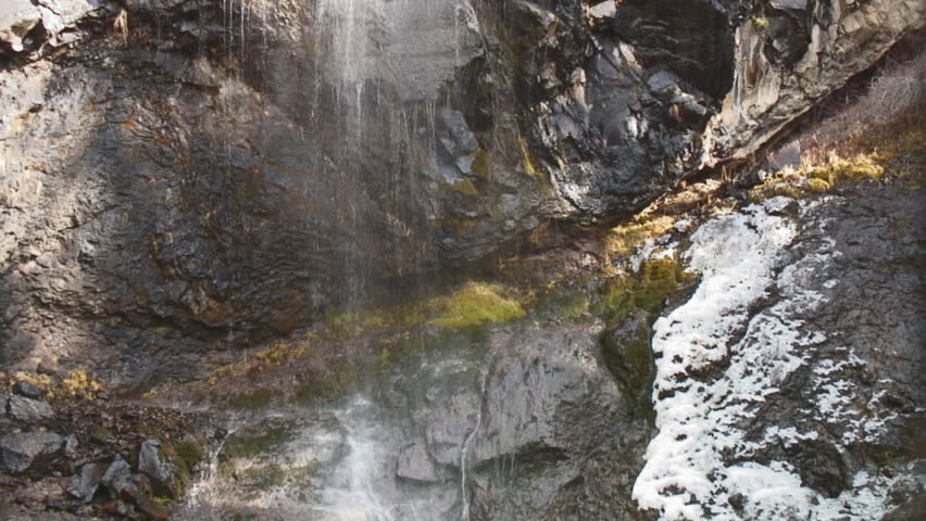 Treasure Falls, Colorado; autumn colored moss and snow frame tight shot of waterfall; HD, audio