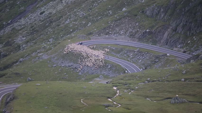 Nice landscape shot of a mountain house with sight to curvy mountain roads in the valley.