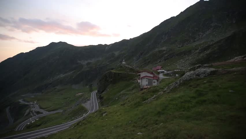 Mountain house with sight to curvy mountain roads in the valley.