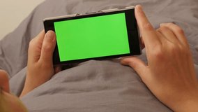 Woman resting in bed and surfing through internet pages on green screen 4K 2160p UltraHD footage - Female on greenscreen phone display 4K 3840X2160 UHD video