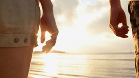 Young romantic couple hold hands at sunset on shore in summer outdoor - gimbal steadicam HD video footage