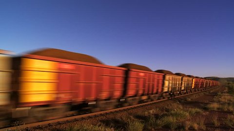 Train with Cargo Carriages Traveling Through Outback Australia