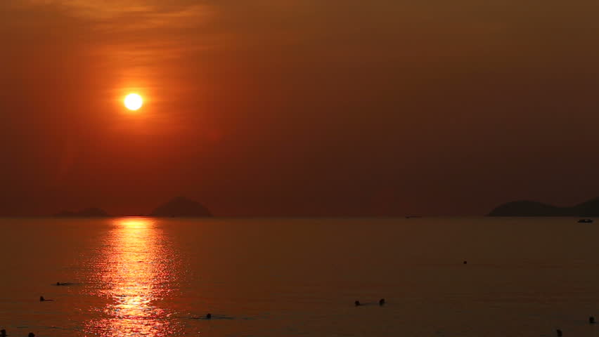 Vietnamese people swim in sea at sunrise against small islands | Shutterstock HD Video #9953006