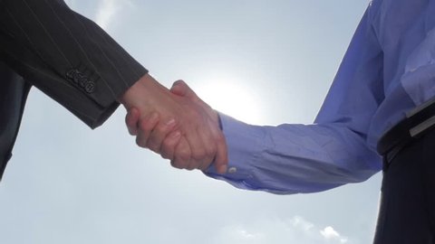Slow motion of a business men handshaking back-light