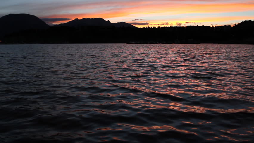 Waves in a lake in the Rocky Mountains reflect the pink sunset. HD 1080p.