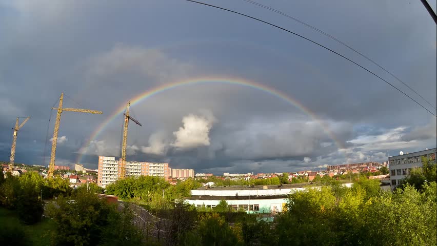Double rainbow over the city. Construction of a multistory building. Domodedovo, Russia. Timelapse