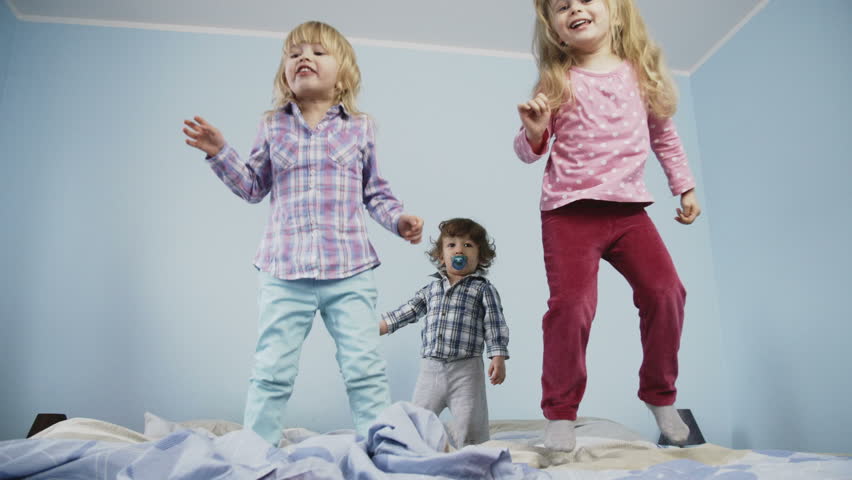 Little kids jumping on bed. Shoot on Digital Cinema Camera in slow motion - ProRes 422 codec.