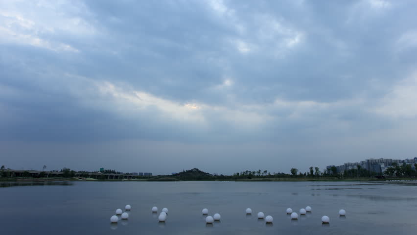 4k timelapse of dark clouds moving fast above a lake at dusk