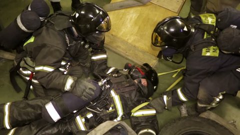 MOSCOW, RUSSIA - MARCH 25, 2015: Training of rescue workers. In a face of strong smoke they need to find a hurt person, move him to a safe area and provide first aid.